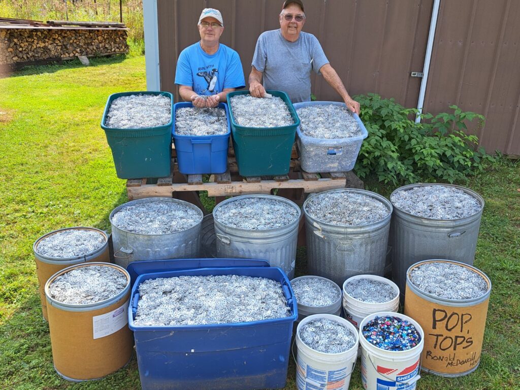 Paul Bothwell and Rick Bothwell posing with all of the pop tabs they have collected over the past 4 years or so. 